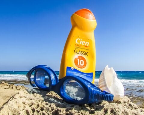 Representative image. Sunscreen, goggles, and seashell on a rocky beach. Photo Source: Dimitrisvetsikas1969 (Pixabay).