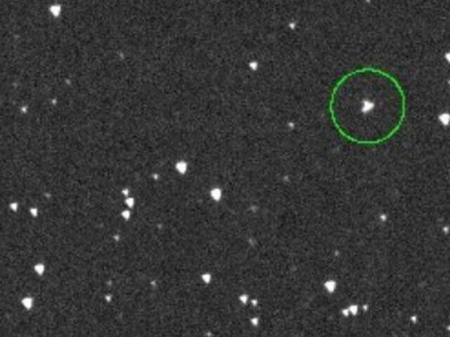 A telescope-captured view of space showing multiple stars or celestial objects. A particular object is highlighted with a green circle, which likely represents the asteroid 2024 YR4. Photo Source: NASA