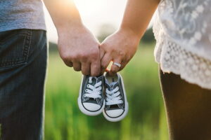 Representative Image: Two person holding baby shoes Photo Source: Pickpik.com