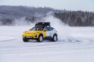 A yellow car in motion on a snowy terrain. Photo Source - Polestar