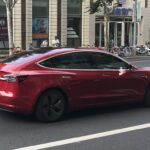 Representative Image. A red Tesla Model 3 electric vehicle driving down a bustling urban street. Photo Source - Jengtingchen (CC BY-SA 4.0)