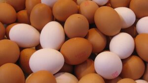 A pile of white and brown eggs, some of which have red ink stamps on them. Photo Source: 16:9clue (CC BY 2.0)