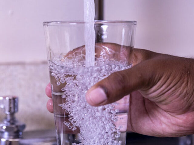 fetching water in glass from tap