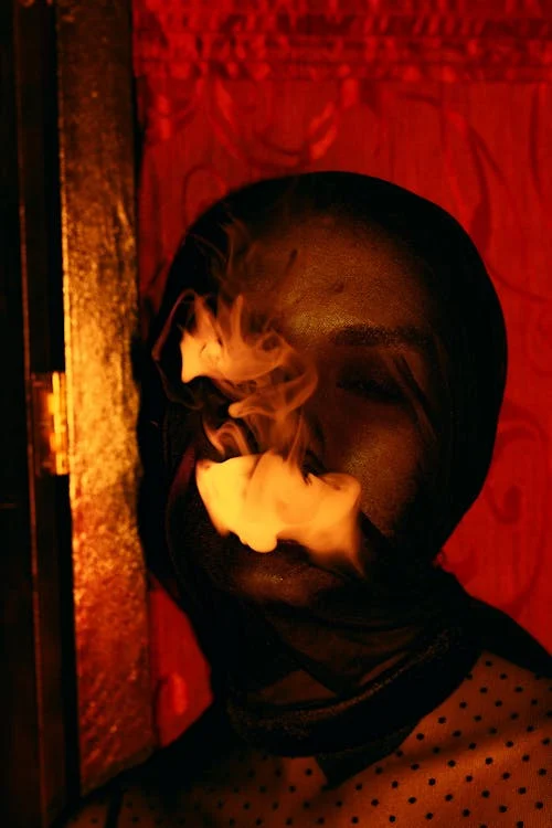 Woman wearing see- through Fabric on Face and smoking Photo Source-PEXELS- Ruslan Rozanov