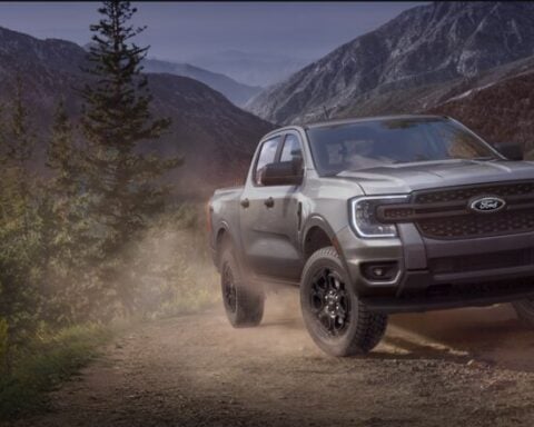 A Ford pickup truck driving on a rugged dirt trail through a scenic mountainous landscape. Photo Source: Ford