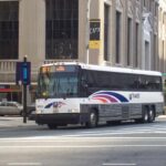 New Jersey Transit MCI #9035, in Newark, New Jersey at Broad Street and Raymond Boulevard on the 67X. Image Source: Adam E. Moreira (CC BY-SA 3.0 US)