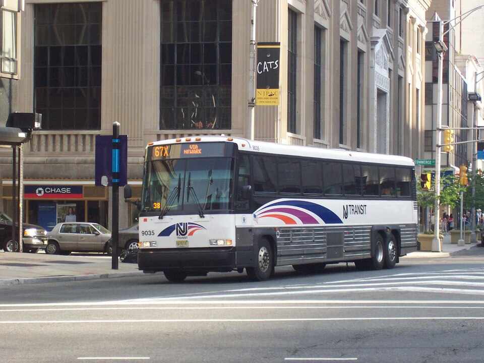 New Jersey Transit MCI #9035, in Newark, New Jersey at Broad Street and Raymond Boulevard on the 67X. Image Source: Adam E. Moreira (CC BY-SA 3.0 US)