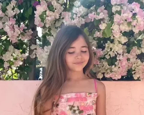 A nine year old Leah smiling against a beach background to support fundraising for her shark‑attack recovery.