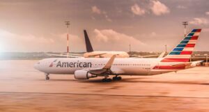 White American Airlines aircraft parked on the runway at Paris Charles de Gaulle Airport during daylight.