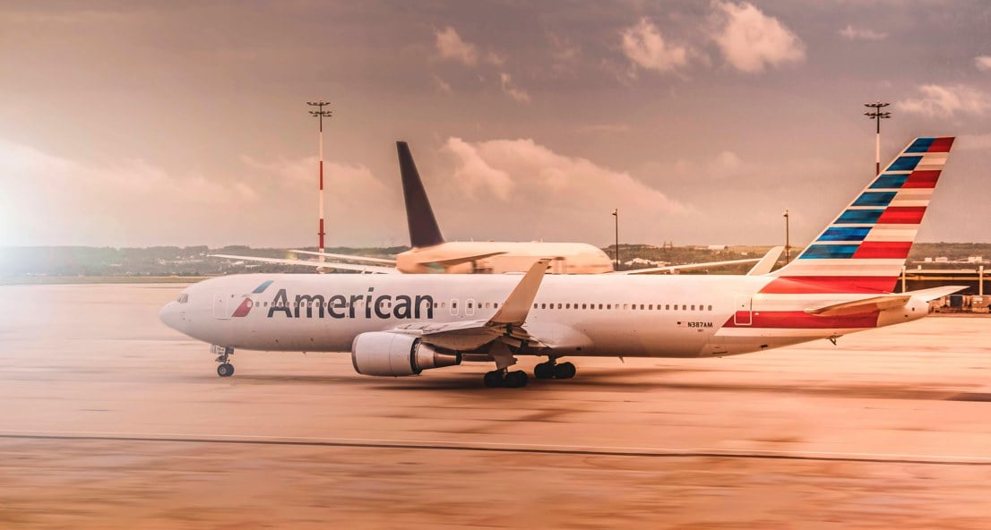 White American Airlines aircraft parked on the runway at Paris Charles de Gaulle Airport during daylight.