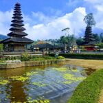 Traditional Balinese temple gate with twin stone towers against a clear blue sky in Bali, Indonesia.