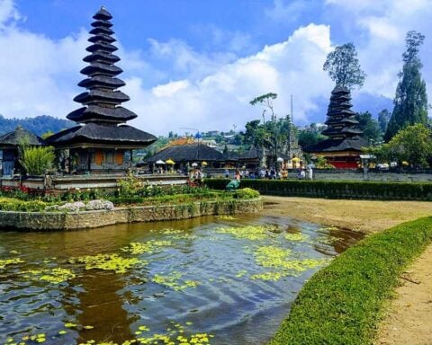 Traditional Balinese temple gate with twin stone towers against a clear blue sky in Bali, Indonesia.