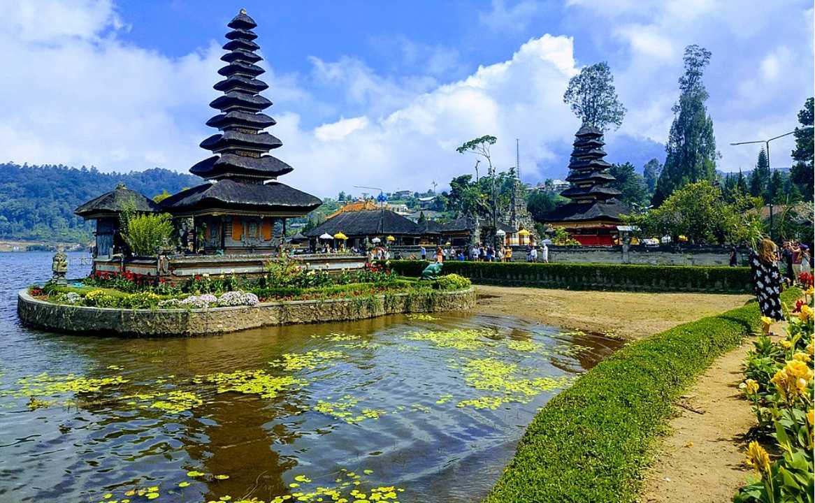 Traditional Balinese temple gate with twin stone towers against a clear blue sky in Bali, Indonesia.