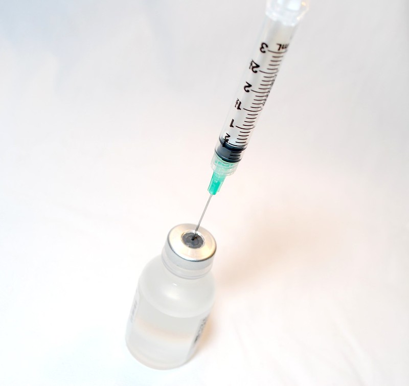 Needle syringe with a vaccine bottle. Photo Source: NIH