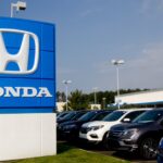 A photograph of the Honda sign at a car dealership.