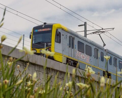 An elevated section of the LA Metro E Line (formerly Expo Line) with a train approaching a station