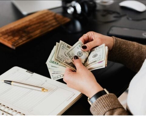 Close-up of women counting us dollar.