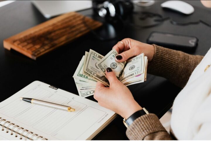 Close-up of women counting us dollar.