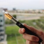Close-up of a vape pen vaporizer holding in hand.