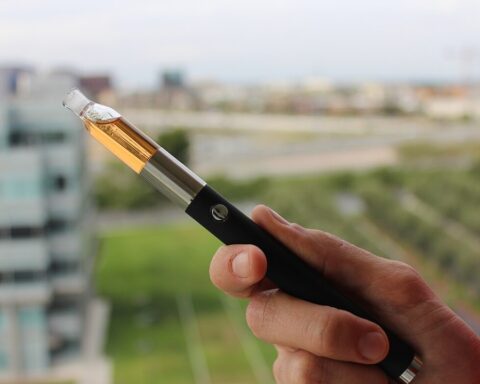 Close-up of a vape pen vaporizer holding in hand.