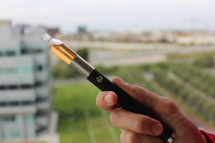 Close-up of a vape pen vaporizer holding in hand.