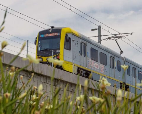An elevated section of the LA Metro E Line (formerly Expo Line) with a train approaching a station.
