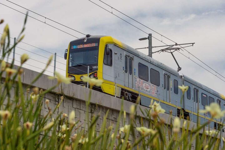An elevated section of the LA Metro E Line (formerly Expo Line) with a train approaching a station.