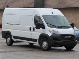 White 2023 Ram ProMaster 2500 cargo van with high roof and 159-inch wheelbase parked in front of brick building, showing front and side view of recalled commercial vehicle