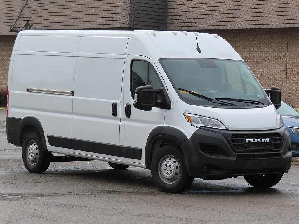 White 2023 Ram ProMaster 2500 cargo van with high roof and 159-inch wheelbase parked in front of brick building, showing front and side view of recalled commercial vehicle