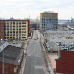 A long road in a city with buildings and cars / A street with a lot of cars parked on it / Public domain stock photo.( Representative Image)