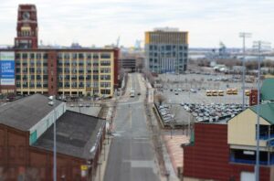 A long road in a city with buildings and cars / A street with a lot of cars parked on it / Public domain stock photo.( Representative Image)