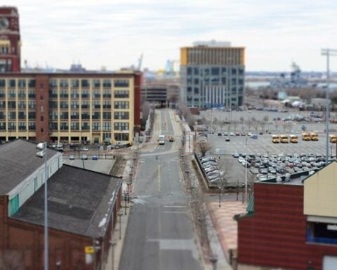 A long road in a city with buildings and cars / A street with a lot of cars parked on it / Public domain stock photo.( Representative Image)