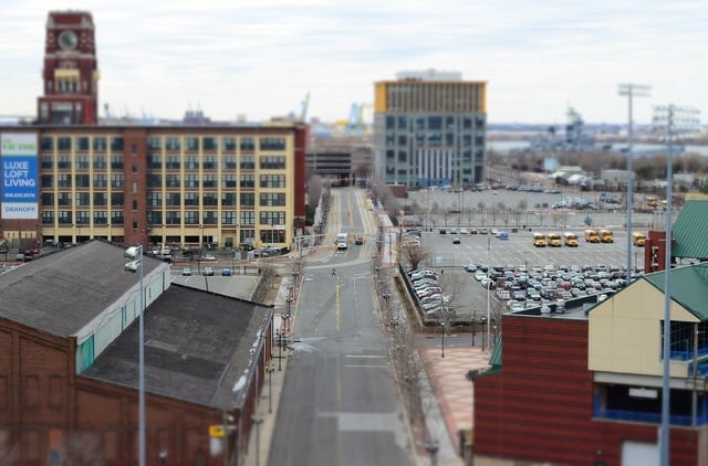 A long road in a city with buildings and cars / A street with a lot of cars parked on it / Public domain stock photo.( Representative Image)