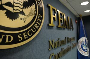 FEMA National Response and Coordination Center interior with FEMA logo, DHS seal, and flag — central hub for U.S. disaster management operations.
