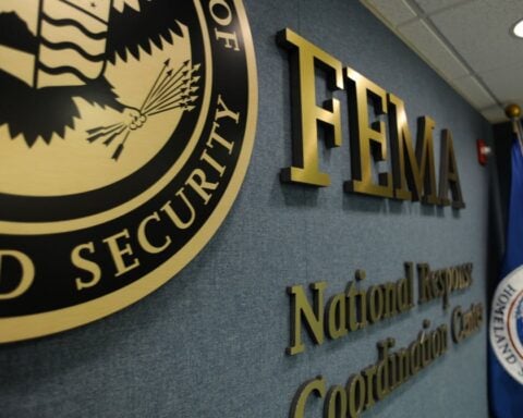 FEMA National Response and Coordination Center interior with FEMA logo, DHS seal, and flag — central hub for U.S. disaster management operations.