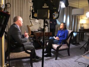 Television interview setup with a guest seated across from an interviewer in a studio room