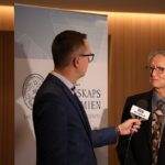 Geoffrey Hinton speaking at a Nobel Prize press conference, discussing unconventional AI safety approaches