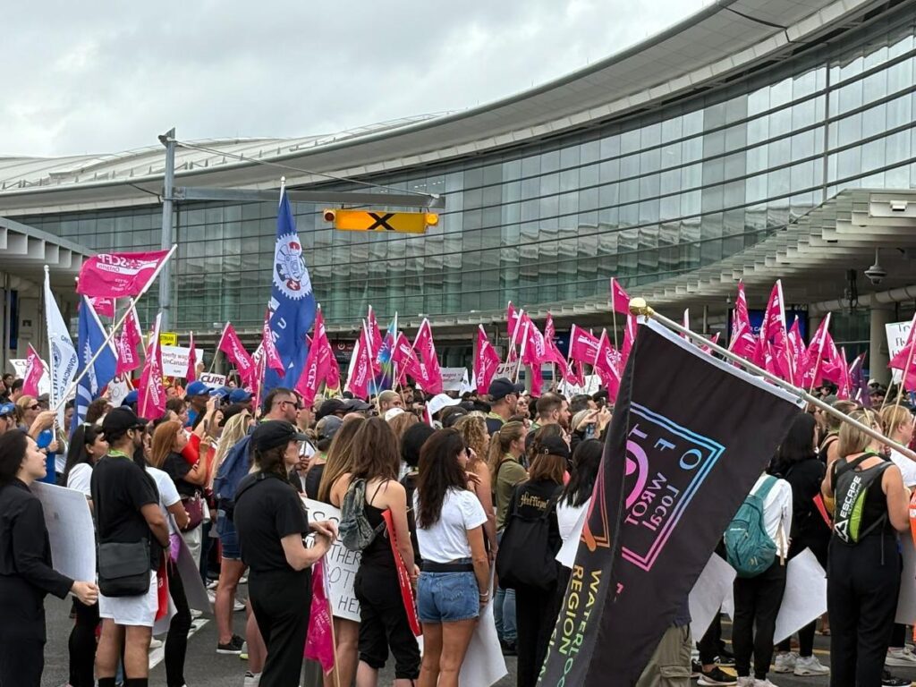 Protesters and labour union members gathered at a solidarity rally for Air Canada flight attendants holding signs, following the unlawful strike declaration.