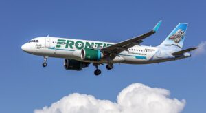 Frontier Airlines Airbus A320neo (N389FR) on final approach at Baltimore–Washington International, side view with animal-tail livery against a clear blue sky.
