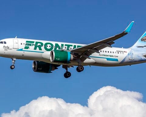 Frontier Airlines Airbus A320neo (N389FR) on final approach at Baltimore–Washington International, side view with animal-tail livery against a clear blue sky.