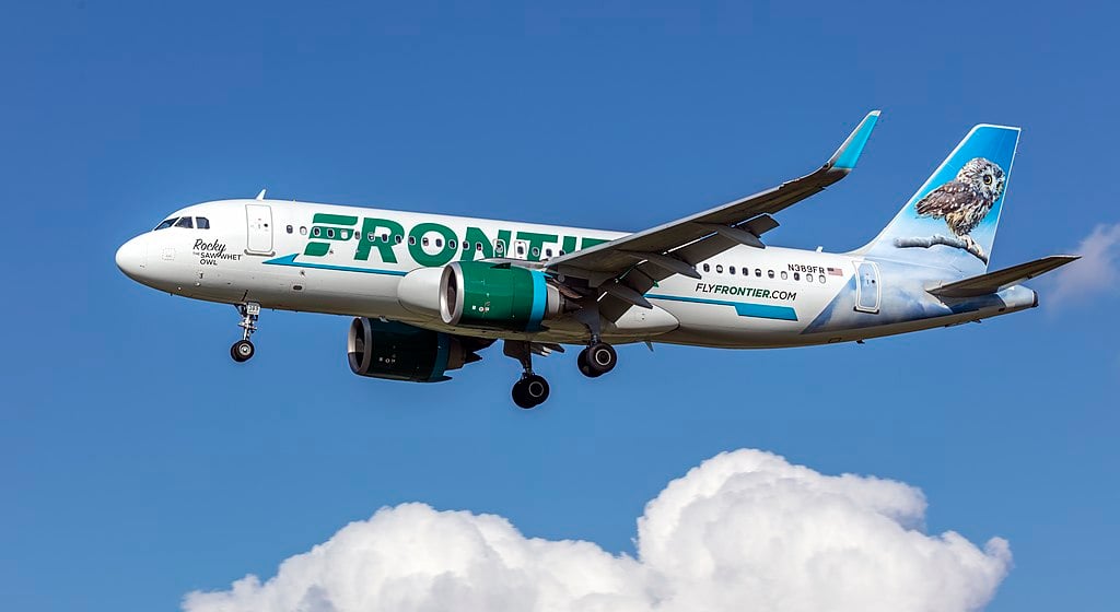 Frontier Airlines Airbus A320neo (N389FR) on final approach at Baltimore–Washington International, side view with animal-tail livery against a clear blue sky.