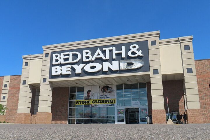 Exterior of a closed Bed Bath & Beyond store in Taylor, Michigan, showing the company's blue and white signage on a brick building façade.