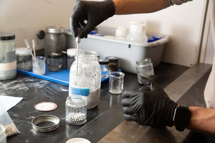 Close-up demonstration of the activation process where aluminum pellets are treated with gallium-indium alloy to enable hydrogen production.