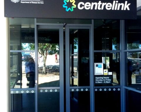 Entrance to a Centrelink service centre with glass doors and signage, representing Australian Government social security services.
