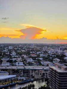 Smoke haze from Everglades wildfires drifting over a Broward County highway under a gray sky.