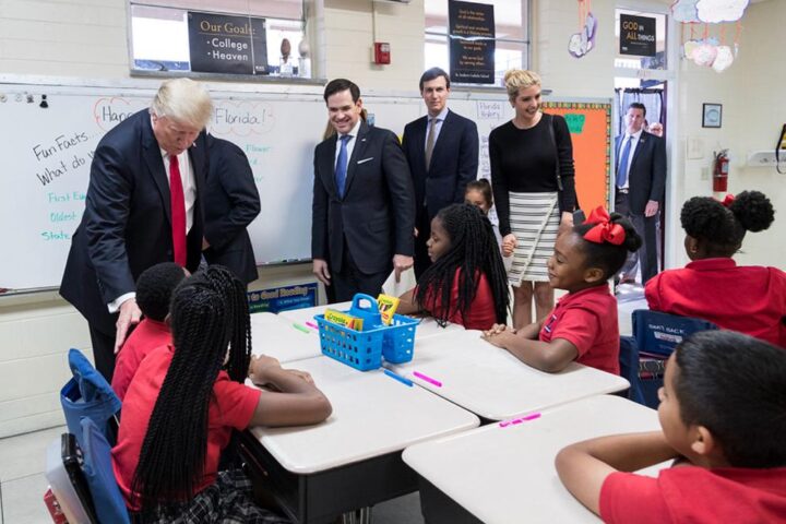 President Trump, Rubio, Kushner, and Ivanka Trump interact with fourth-grade students in a decorated classroom at Saint Andrew's Catholic School.