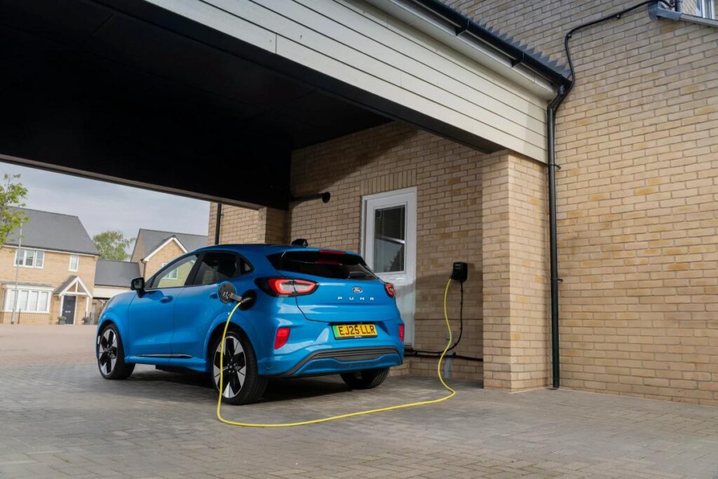 Blue Ford Puma Gen-E electric car charging at a home wall box in the UK.