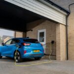 Blue Ford Puma Gen-E electric car charging at a home wall box in the UK.