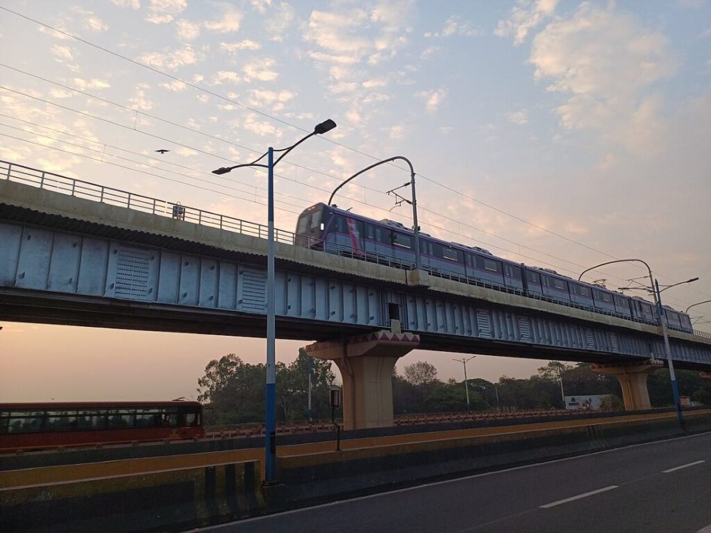 Pune Metro train running on the elevated viaduct between Bopodi and Dapodi during sunset.