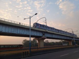 Pune Metro train running on the elevated viaduct between Bopodi and Dapodi during sunset.